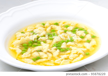 chicken bouillon with homemade dumplings and green peas 93878220