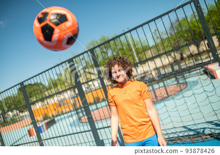 Serious concentrated adolescent practicing basketball shots outdoors 93878426