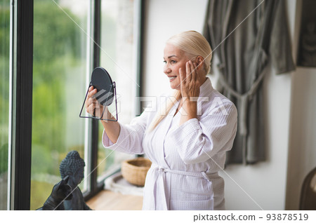 Mid aged pretty woman looking at the mirror 93878519