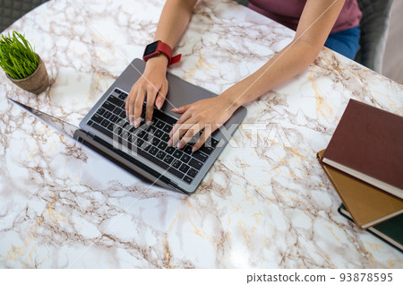 Close up of girls hands on the laptop keyboard 93878595