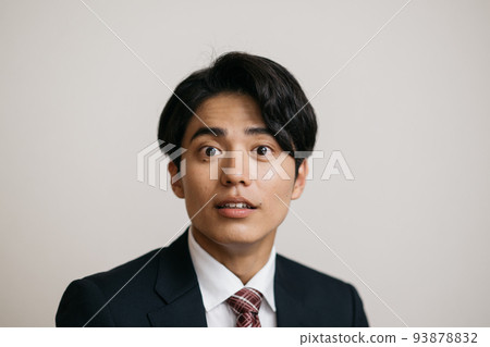 二十多歲的商人穿著西裝,臉上帶著驚訝 二十多歲的商人穿著西裝,臉上帶著驚訝 93878832
