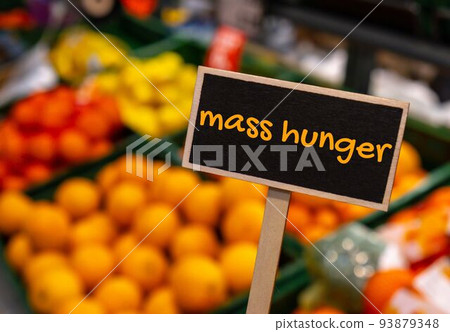 Wooden information label sign with text MASS HUNGER against defocused store shelves message. Global hunger, inflation, high prices, increasing living expenses and poverty, financial crisis, food Wooden information label sign with text MASS HUNGER against defocused store shelves message. Global hunger, inflation, high prices, increasing living expenses and poverty, financial crisis, food 93879348
