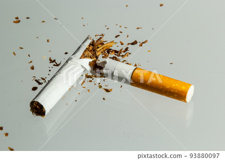 Broken cigarette fly in air on a light background. Conception of combating smoking Broken cigarette fly in air on a light background. Conception of combating smoking 93880097