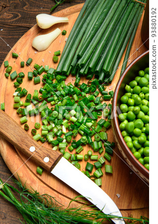 green onions, dill and peas on a wooden background, still life, sliced vegetables on a kitchen board, concept of fresh and healthy food green onions, dill and peas on a wooden background, still life, sliced vegetables on a kitchen board, concept of fresh and healthy food 93880192