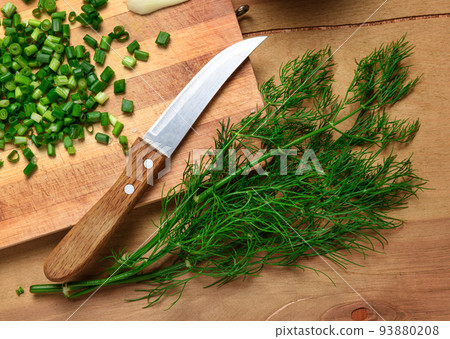 vegetables on a wooden kitchen board, sliced green onions, dill and peas on a wood background, concept of fresh and healthy food, still life vegetables on a wooden kitchen board, sliced green onions, dill and peas on a wood background, concept of fresh and healthy food, still life 93880208
