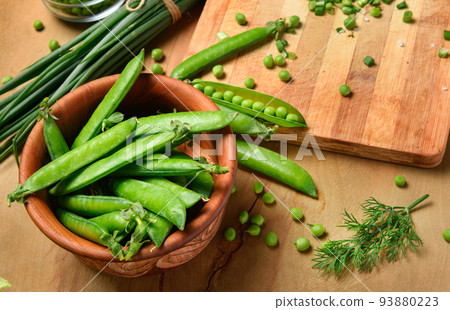 vegetables on a wooden kitchen board, sliced green onions, dill and peas on a wood background, concept of fresh and healthy food, still life vegetables on a wooden kitchen board, sliced green onions, dill and peas on a wood background, concept of fresh and healthy food, still life 93880223