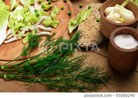 vegetables on a wooden kitchen board, green onions, dill and peas, sliced cabbage on a wood background, concept of fresh and healthy food, still life vegetables on a wooden kitchen board, green onions, dill and peas, sliced cabbage on a wood background, concept of fresh and healthy food, still life 93880240