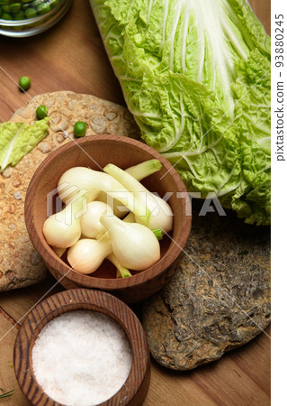 vegetables on a wooden kitchen board, green onions, dill and peas, sliced cabbage on a wood background, concept of fresh and healthy food, still life vegetables on a wooden kitchen board, green onions, dill and peas, sliced cabbage on a wood background, concept of fresh and healthy food, still life 93880245