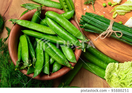 vegetables on a wooden kitchen board, sweet green peas and dill, leek and cabbage on a wood background, concept of fresh and healthy food, still life 93880251