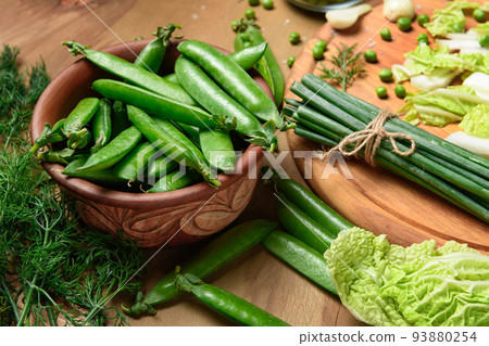 vegetables on a wooden kitchen board, sweet green peas and dill, leek and cabbage on a wood background, concept of fresh and healthy food, still life vegetables on a wooden kitchen board, sweet green peas and dill, leek and cabbage on a wood background, concept of fresh and healthy food, still life 93880254