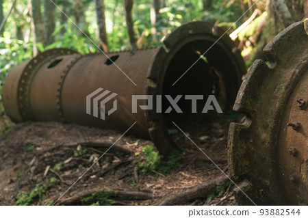 remains of rusty industrial equipment among the forest 93882544