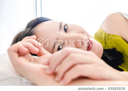 A sleeping young woman looking at the camera 93883039