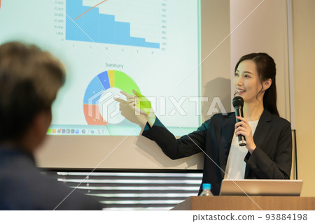 Young woman speaking into a microphone at a seminar 93884198