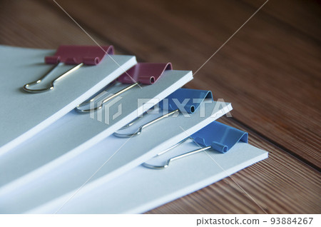Paper stack of clipped pile of documents on wooden desk. Copy space and business offices concept Paper stack of clipped pile of documents on wooden desk. Copy space and business offices concept 93884267