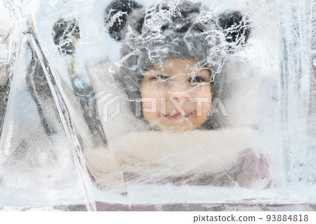 a child smiling while looking at a large ice floe a child smiling while looking at a large ice floe 93884818