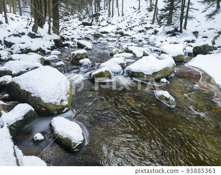 Snow covered stones in Mumlava river stream in Krkonose National Park, Czech Republic, winter seasonal background 93885363