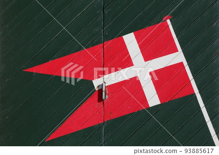 Danish flag on a green door in Denmark 93885617