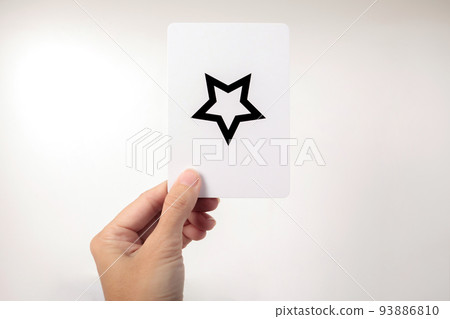 Woman's hand showing a Zener card with a star. White background 93886810