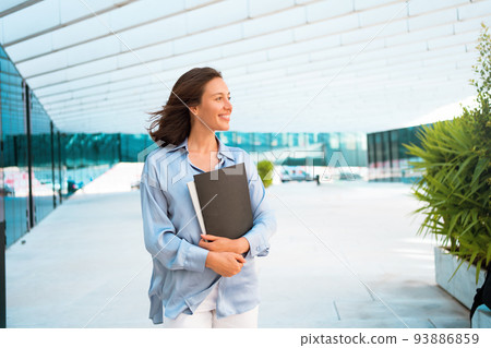 Businesswoman successful woman business person walking outdoor corporate building exterior Excited happy cute caucasian positive professional business female person 93886859