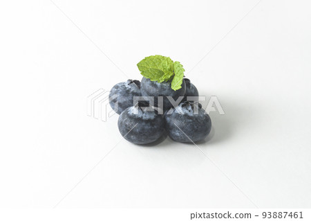 Blueberries and a mint leaf on a white background Blueberries and a mint leaf on a white background 93887461