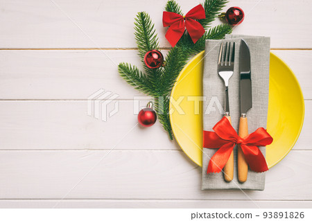 Christmas table place setting with christmas decor and plates, kine, fork and spoon. Christmas holiday background. Top view with copy space Christmas table place setting with christmas decor and plates, kine, fork and spoon. Christmas holiday background. Top view with copy space 93891826