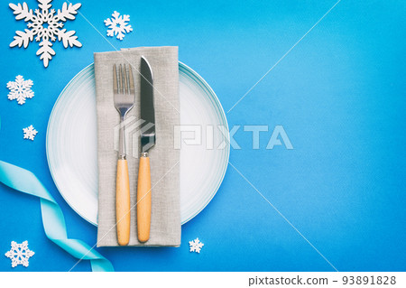 Christmas table place setting with christmas decor and plates, kine, fork and spoon. Christmas holiday background. Top view with copy space Christmas table place setting with christmas decor and plates, kine, fork and spoon. Christmas holiday background. Top view with copy space 93891828