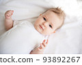 Charming baby on a white bed in the bedroom. 93892267