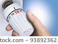 Man reducing energy consumption by setting thermostat temperature to 19 degrees. 93892362