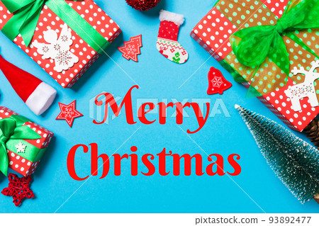Merry Christmas text. Top view of Christmas decorations on blue background. New Year holiday concept with copy space Merry Christmas text. Top view of Christmas decorations on blue background. New Year holiday concept with copy space 93892477