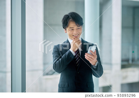 一位穿著西裝的中產階級商人在辦公室裡操作智能手機 93893296