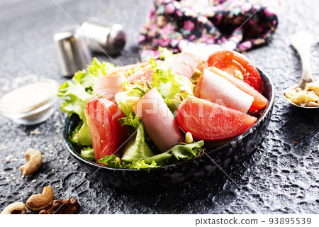 Fresh vegetable salad with slices of ham , cherry tomatoes lettuce leaves. Ham salad. Take away food. Fresh vegetable salad with slices of ham , cherry tomatoes lettuce leaves. Ham salad. Take away food. 93895539