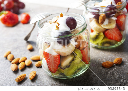 Summer fruit salad with white cream and almonds 93895843