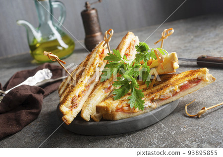 Toast with ham and cheese served on sandwich plate on a stone table 93895855