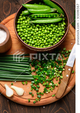 green sweet peas on a dark wooden background, onion and fennel, salt, still life of fresh and healthy food green sweet peas on a dark wooden background, onion and fennel, salt, still life of fresh and healthy food 93896567