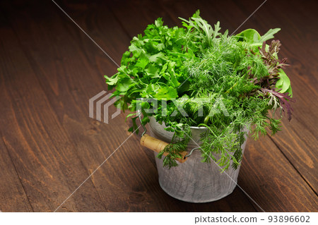 a bunch of green dill, parsley, salad and other greens in an iron bucket, dark wooden background, concept of fresh vegetables and healthy food a bunch of green dill, parsley, salad and other greens in an iron bucket, dark wooden background, concept of fresh vegetables and healthy food 93896602