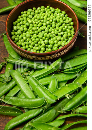 green sweet peas on a dark wooden background, still life, concept of fresh and healthy food green sweet peas on a dark wooden background, still life, concept of fresh and healthy food 93896653