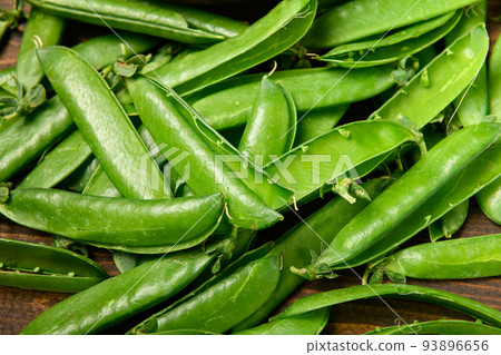 green sweet peas on a dark wooden background, still life, concept of fresh and healthy food green sweet peas on a dark wooden background, still life, concept of fresh and healthy food 93896656