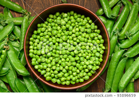 green sweet peas on a dark wooden background, still life, concept of fresh and healthy food green sweet peas on a dark wooden background, still life, concept of fresh and healthy food 93896659