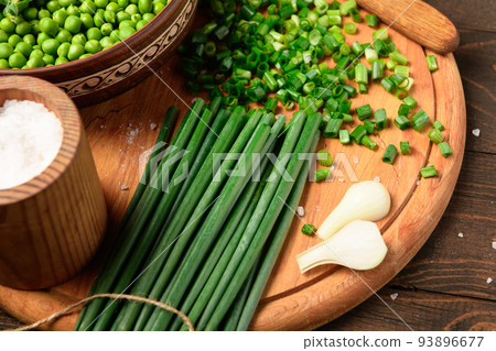 green sweet peas on a dark wooden background, onion, salt, still life, concept of fresh and healthy food green sweet peas on a dark wooden background, onion, salt, still life, concept of fresh and healthy food 93896677
