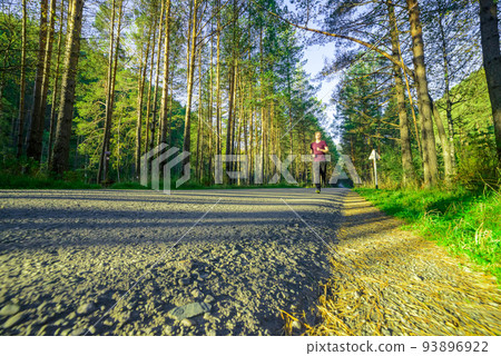 Man jogging in city partk at beautiful summer day. Sport fitness model caucasian ethnicity training outdoor. 93896922