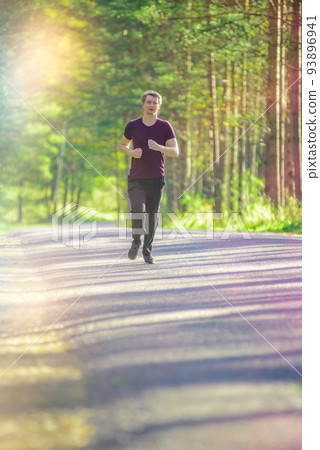 Man jogging in city partk at beautiful summer day. Sport fitness model caucasian ethnicity training outdoor. 93896941