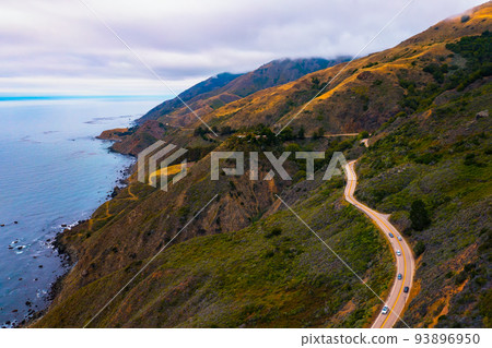 Aerial view of the Pacific Coast Highway going along the coastline of California 93896950