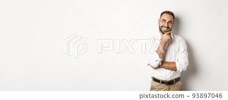 Satisfied businessman having interesting idea, looking at upper left corner and thinking with pleased smile, standing over white background 93897046