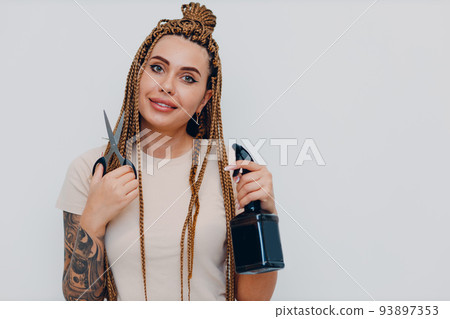 Hairstylist braided afro braids dreadlocks kanekalon pigtails hair portrait with scissors and spray gun Hairstylist braided afro braids dreadlocks kanekalon pigtails hair portrait with scissors and spray gun 93897353