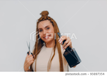 Hairstylist braided afro braids dreadlocks kanekalon pigtails hair portrait with scissors and spray gun 93897354