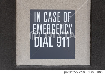 Gray sign on the wall depicting the emergency number, sign with inscription: in case of emergency dial 911 Gray sign on the wall depicting the emergency number, sign with inscription: in case of emergency dial 911 93898088