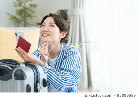 Middle woman preparing to travel (smartphone, passport) 93899689