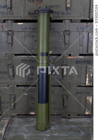 RPG anti-tank rocket propelled grenade launcher with HEAT grenade on army green crate. Text in russian - type of ammunition, projectile caliber, projectile type, number of pieces and weight. 93900584
