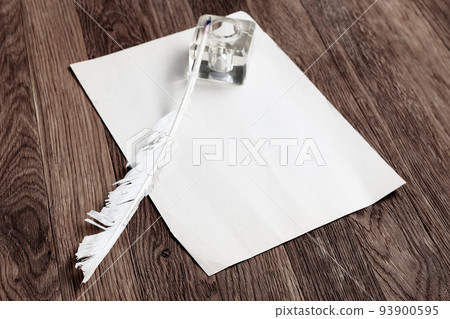 Vintage fountain pen with inkwell and empty sheet of paper on a wooden table Vintage fountain pen with inkwell and empty sheet of paper on a wooden table 93900595