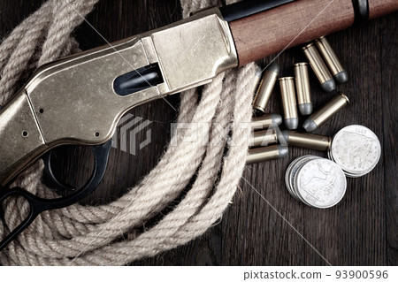 Old west gun - lever-action repeating rifles with ammunition and silver dollar coins. 93900596